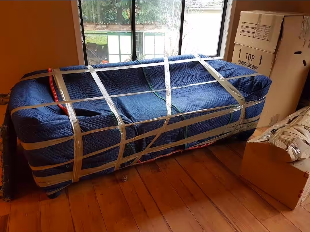 Long Distance Movers couch carefully wrapped and secured with moving blankets for safe transportation